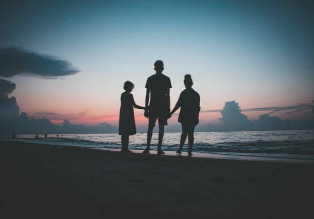 A family holding hands on a beach